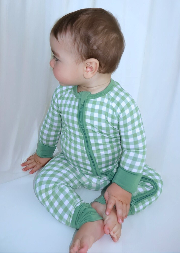 Baby wearing the Goodnight Goose green gingham bamboo zipper romper in a lifestyle photo.